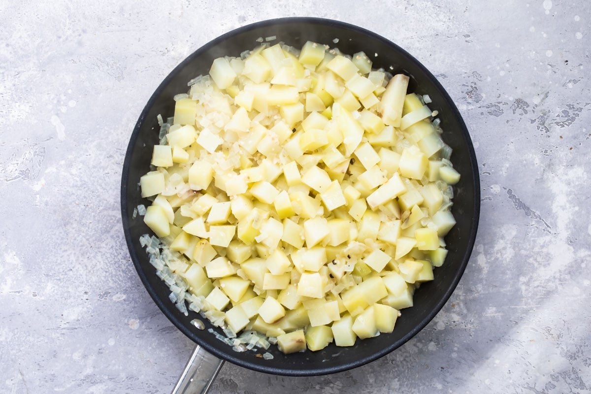 Potatoes cooking in a skillet.